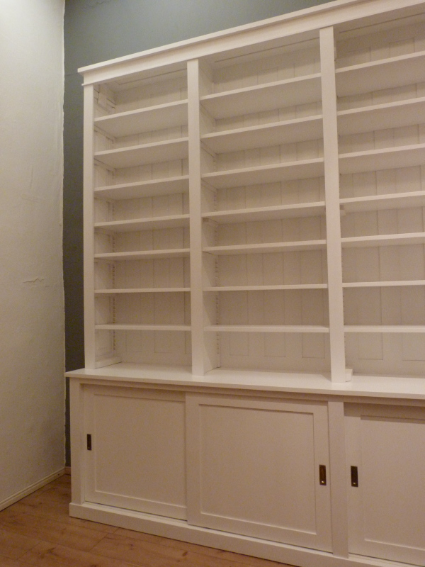 Bücherwand mit Schiebetüren, Erle Massivholz, weiss lasiert Bücherwand mit Schiebetüren, Erle Massivholz, weiss lasiert