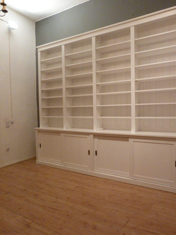 Bücherwand mit Schiebetüren, Erle Massivholz, weiss lasiert Bücherwand mit Schiebetüren, Erle Massivholz, weiss lasiert