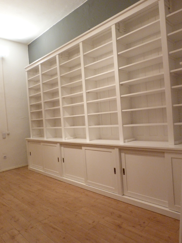 Bücherwand mit Schiebetüren, Erle Massivholz, weiss lasiert Bücherwand mit Schiebetüren, Erle Massivholz, weiss lasiert