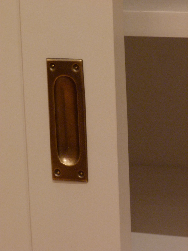 Bücherwand mit Schiebetüren, Erle Massivholz, weiss lasiert Bücherwand mit Schiebetüren, Erle Massivholz, weiss lasiert