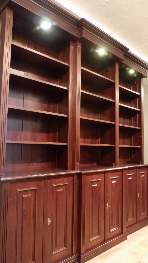 Klassiches Bücherrgegal mit geschlossenem Unterbau und Beleuchtung