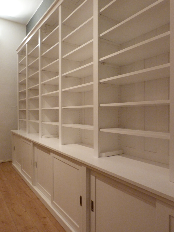 Bücherwand mit Schiebetüren, Erle Massivholz, weiss lasiert